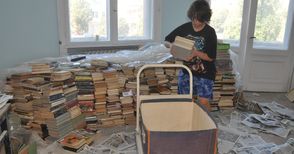 Доброволци редят книги в библиотеката