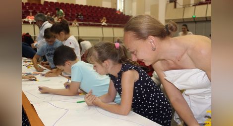 Наталия Кръстева гледа рисунките на малките академици.  Снимка: РУ