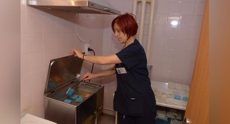 Старши рехабилитаторът Милена Аспарухова подгрява компреси във вана с луга за лечение на болни места след травми. 	        Снимки:Бисер ТОДОРОВ