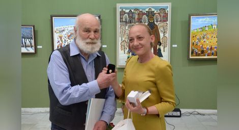 Зам.-кметът Наталия Кръстева връчи златна значка „Русе“ на художника. Снимка: Красимир СТОЯНОВ