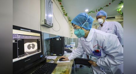 Медици гледат клиничната картина на пациент в болницата в Ухан