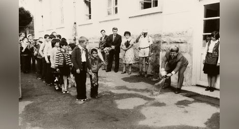 Директорът Никола Попниколов открива новата 1980 учебна година с менче с вода. &bdquo;Да върви по вода.&ldquo;