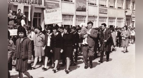 Първомайска манифестация на Основното училище пред трибуната. Вдясно: Никола Попниколов &ndash; директор, носи дъщеричката си Мариянка Николова, Поликрайще, 1 май 1966 г.