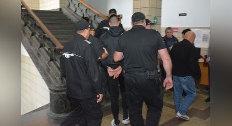 Полицаи водят Д.М. към съдебната зала в Русе. Снимка: Архив