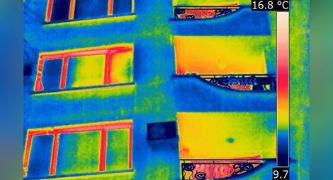 Така изглежда жилищна сграда, снимана с термокамера. Червените участъци показват откъде излиза най-много топлина.