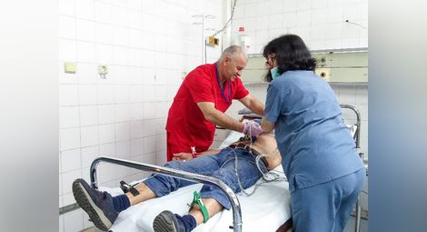 Пламен Симеонов помага на медицинска сестра да направи кардиограма на пациент със сърдечни проблеми в Спешно приемно отделение към Университетска болница „Канев“.               Снимки: Авторът