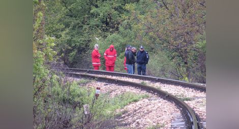 Разследващи полицаи, униформени и медици от Спешна помощ оглеждаха жп линията, до която е намерен 77-годишният мъж. 				 Снимка: Красимир СТОЯНОВ