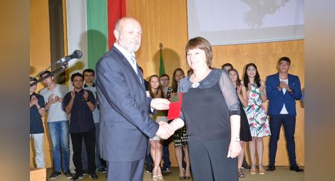 Директорът на гимназията Митко Кунчев връчва на преподавателката по английски Наташа Николова наградата за цялостен принос.                                                Снимка: Красимир СТОЯНОВ